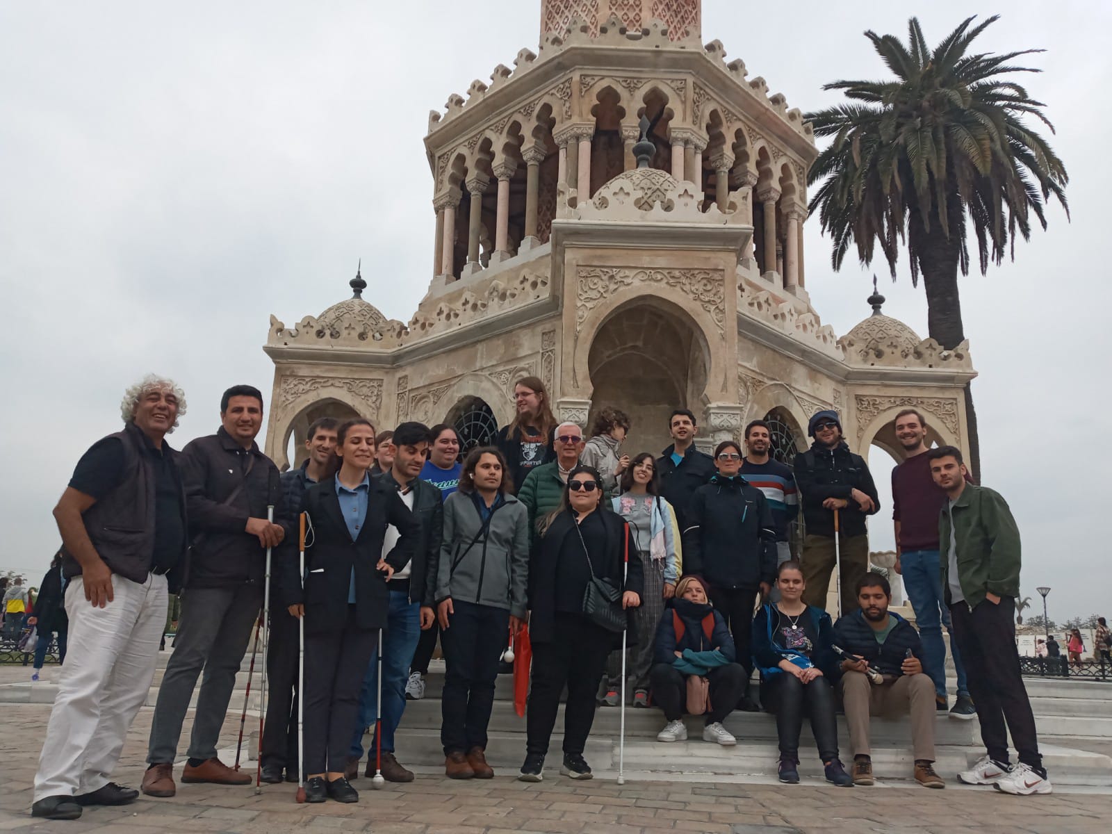 The participants from all the countries are staying in front of the Clock Tower, smiling