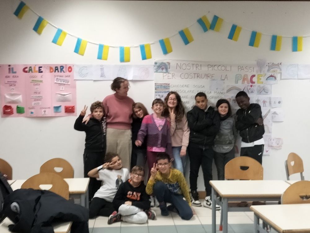 Zoë, together with ten children are smiling at the camera.