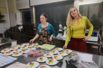 Patricia with Anca setting up the dishes to serve at the Dinner in the Dark
