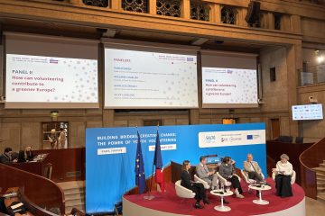 The stage with four panelists and a moderators sitting during the session "how can volunteering contribute to a greener Europe?" In the background, the screens with the title of the panel