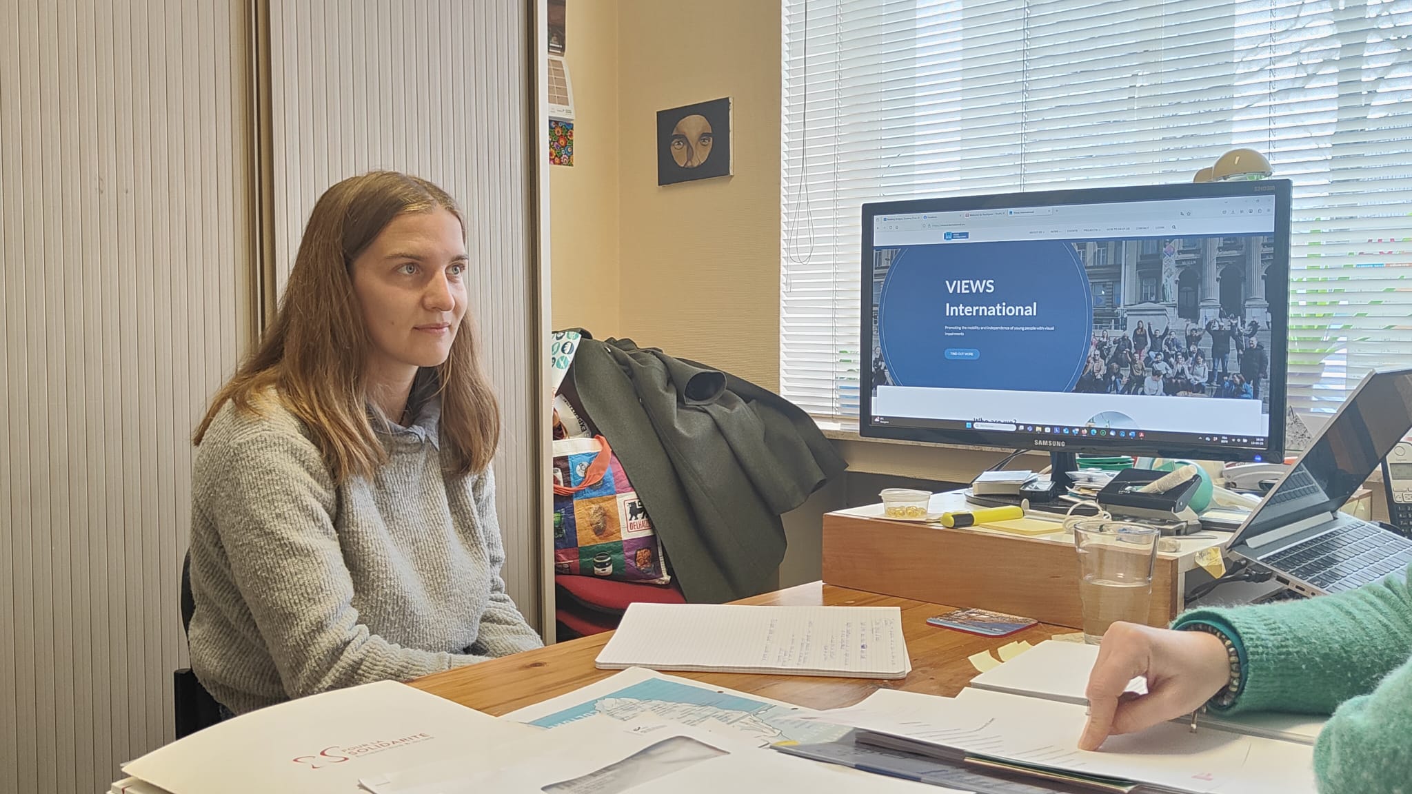 A picture of Lorie in VIEWS International's office, with documents in front of her.