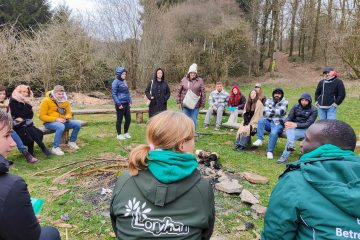 Participants sitting in a circle in a field in Botassart, discussing about sustainable practices.