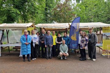 Group photo of participants in front of the stand