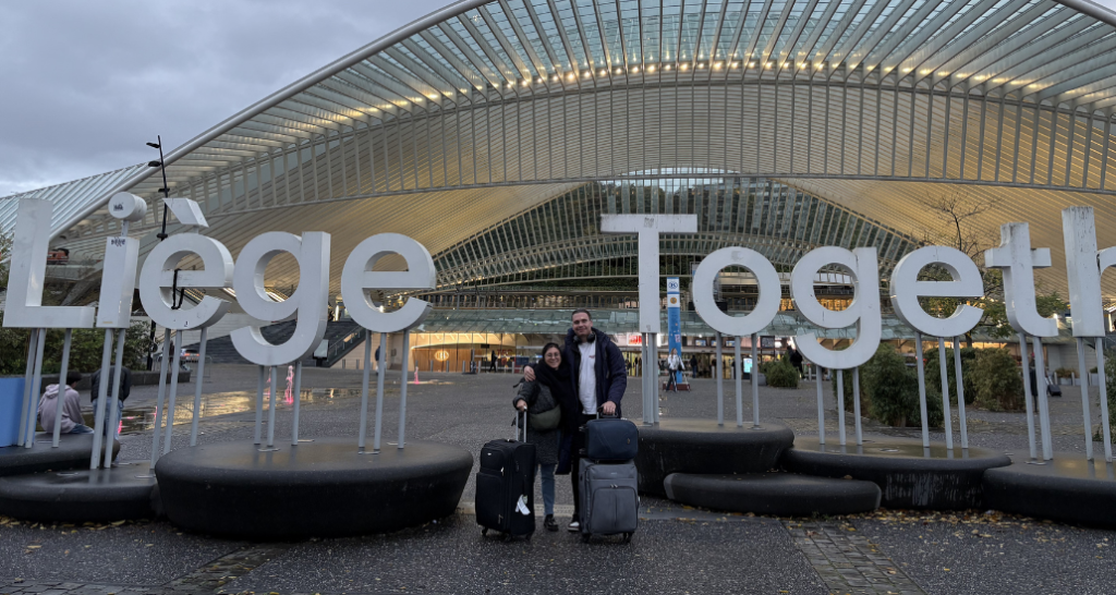 Silviu and Sofia with their suitcases in front of the Liège Together sign