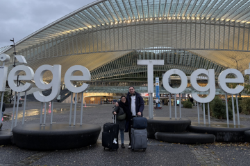 Silviu and Sofia with their suitcases in front of the Liège Together sign
