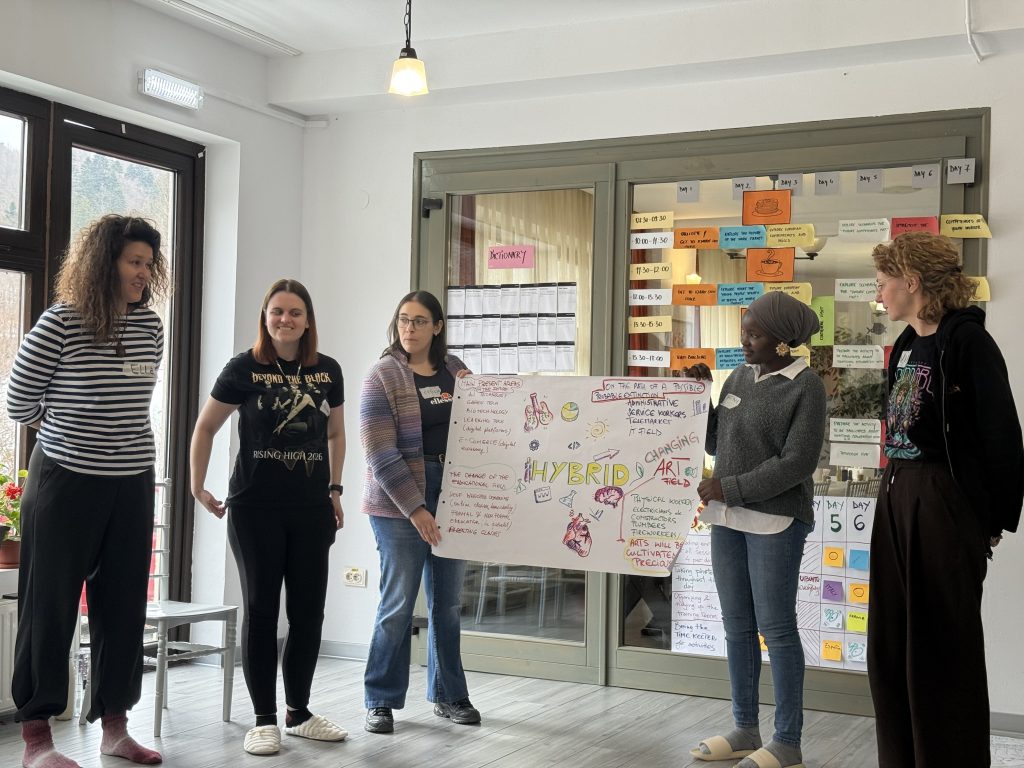 A group of participants listening and presenting during an indoor workshop activity.