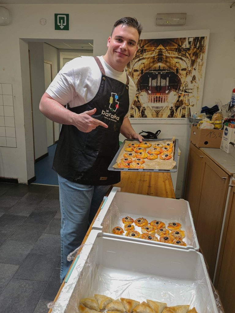 Silviu baking mini pizzas wearing a la baraka apron