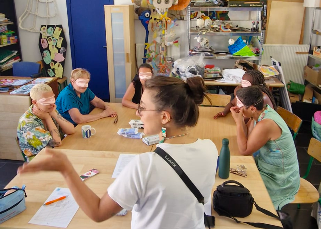 Sofia at La Baraka introducing her awareness-raising activity with clay to a group of women wearing blindfolds.