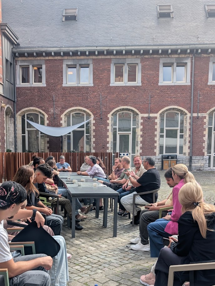 Participants sitting around a line of tables, discussing
