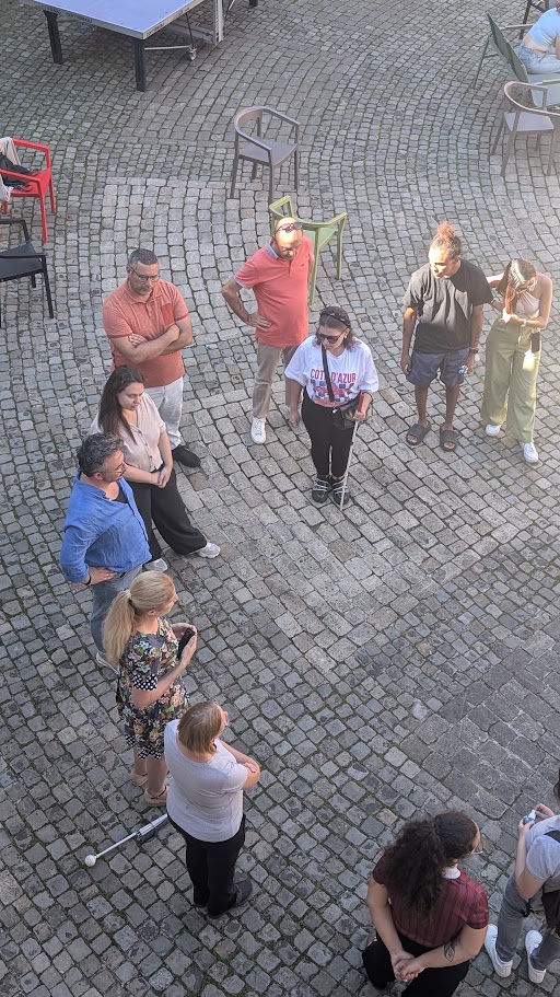 Photo of participants taken from above, as they are standing in a semicircle in the courtyard